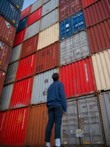Person looking at stack of shipping containers.